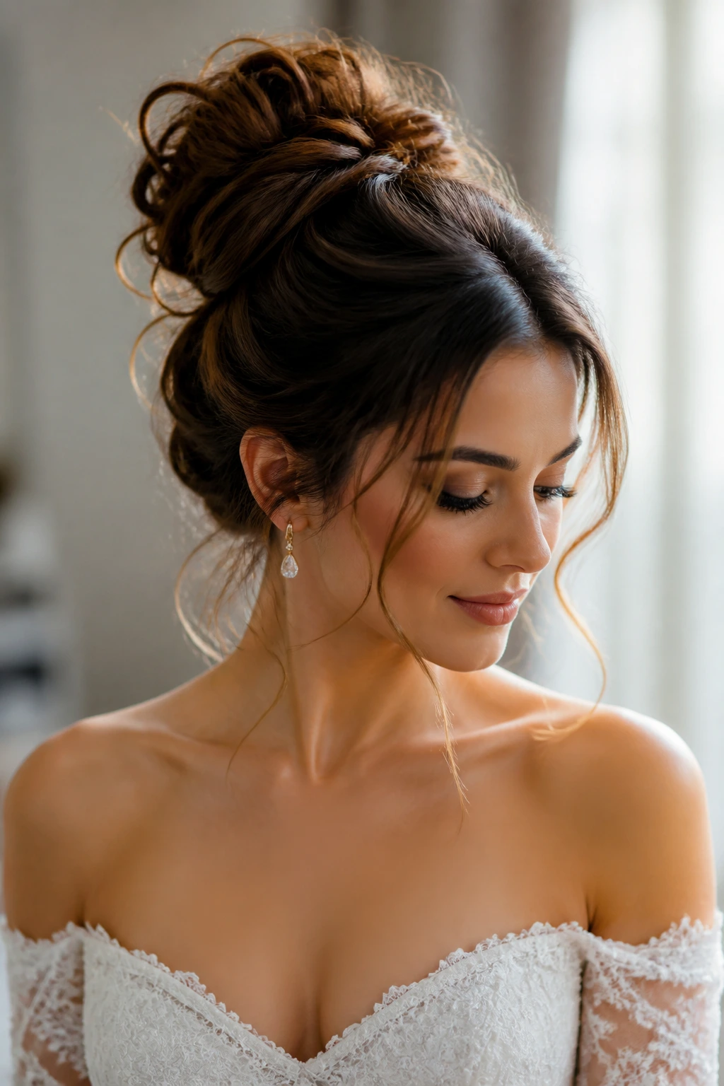 Bride with a high, loose bun and bare shoulders.