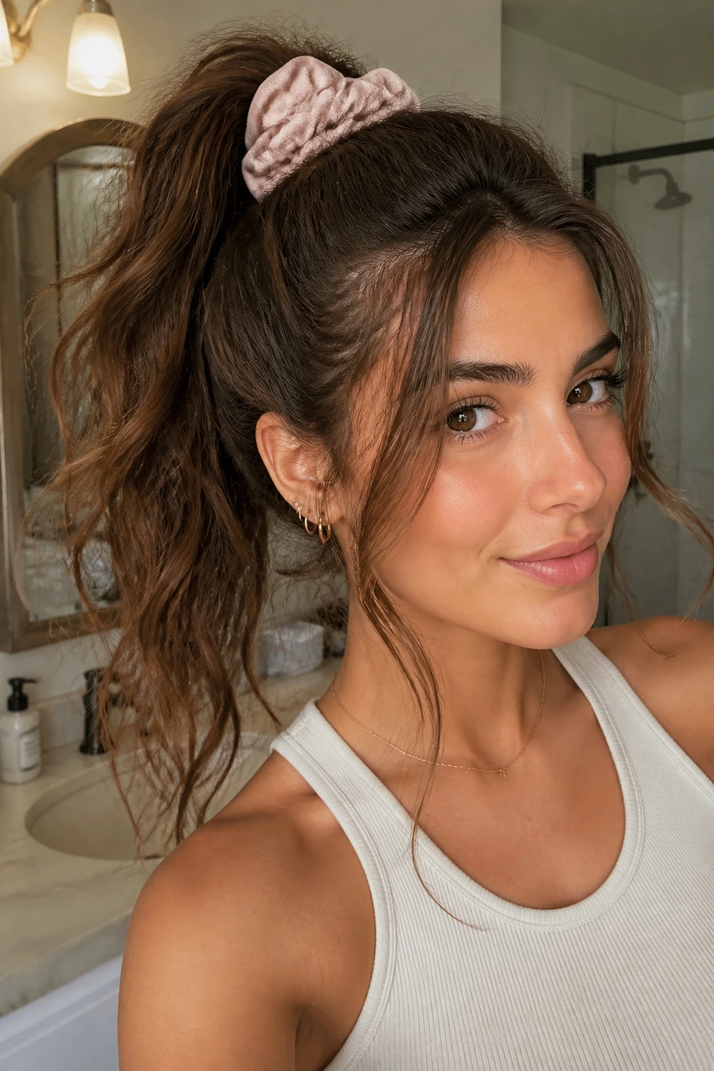 Woman with high scrunchie ponytail and loose face-framing strands