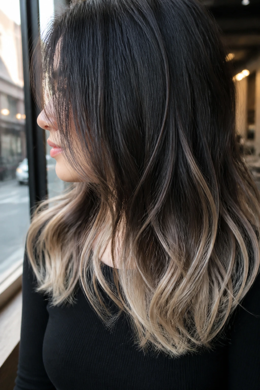 Close-up of mid-length hair with icy beige tips and dark roots.