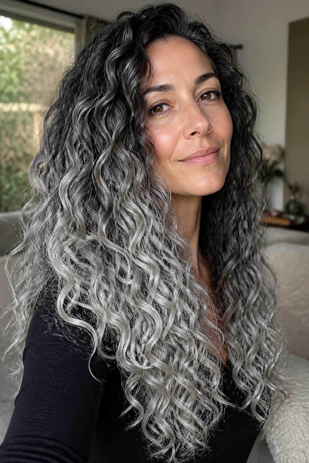 Close-up of a real person with long curly hair and icy silver tips.