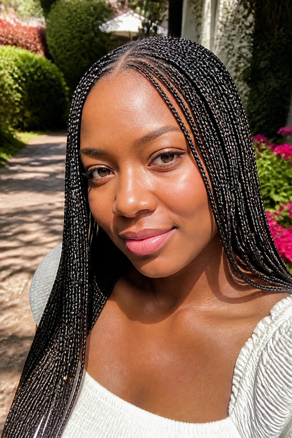Close-up portrait of a real woman with small knotless braids and seed beads.