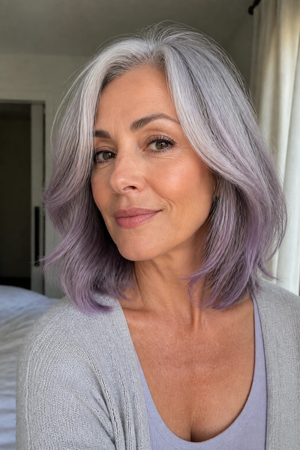 Close-up of a real woman with shoulder-length gray hair and lavender-silver glaze