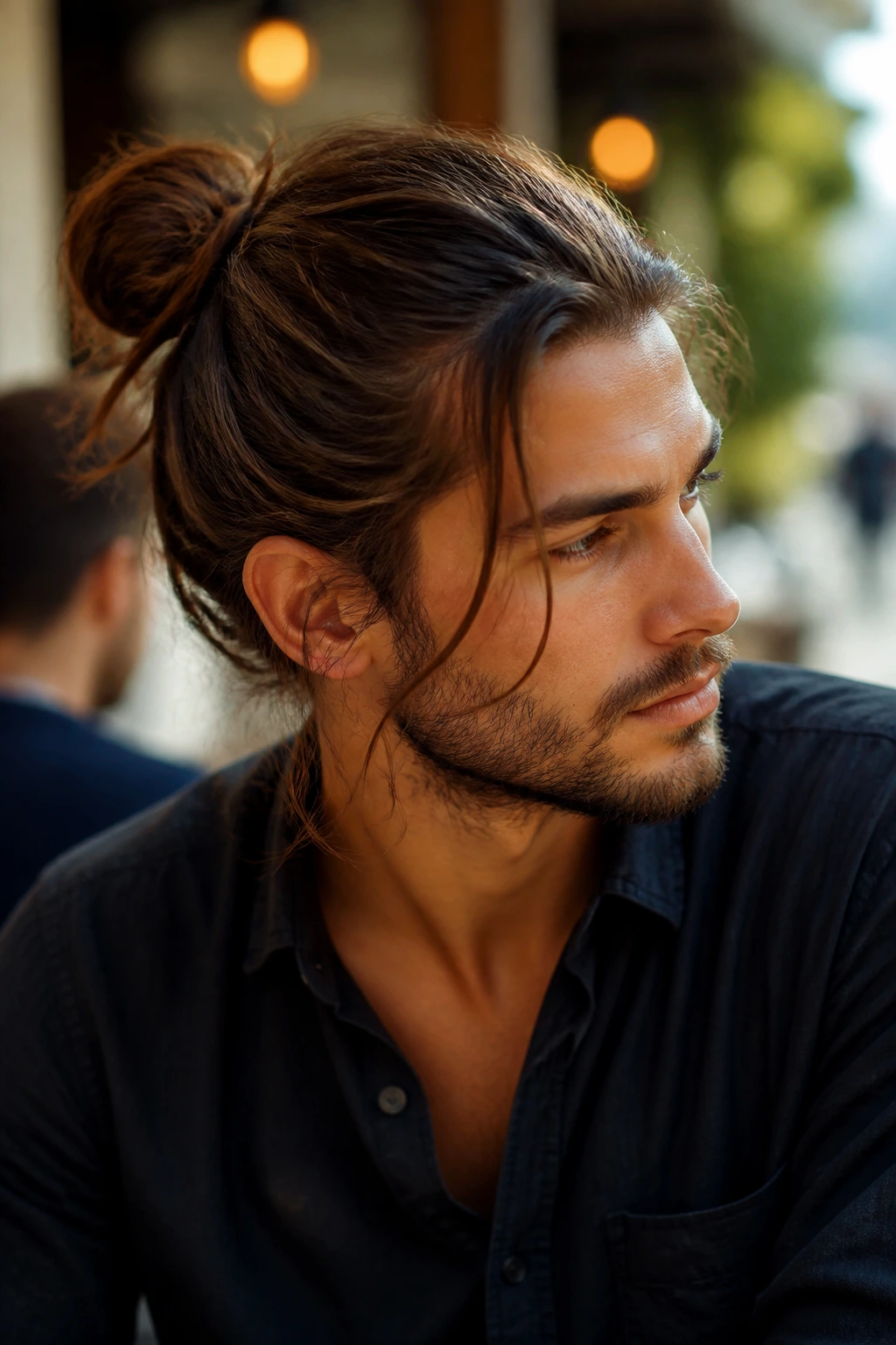 Close-up of a man with a loose man bun