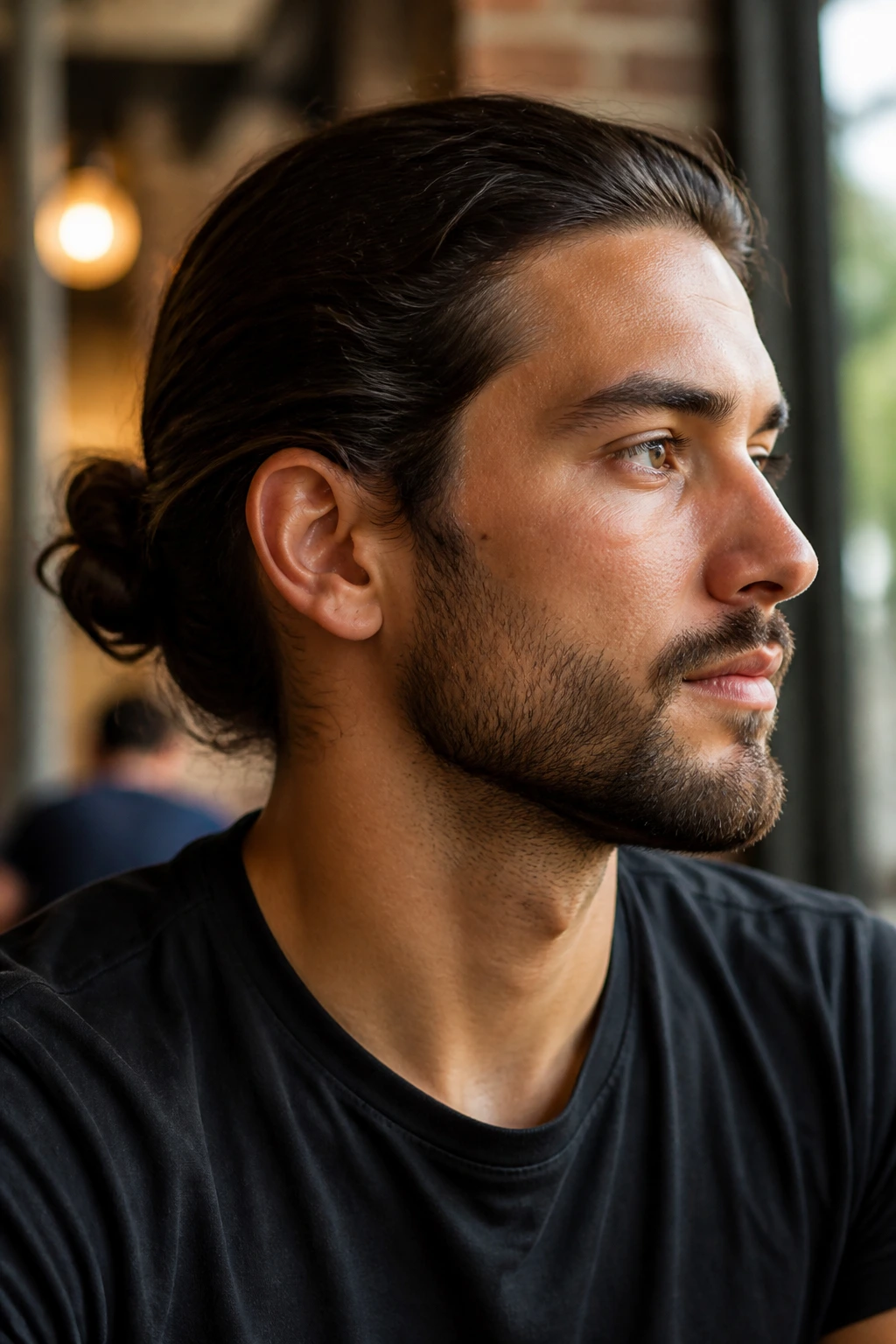 Portrait of a man with a low top knot near the nape