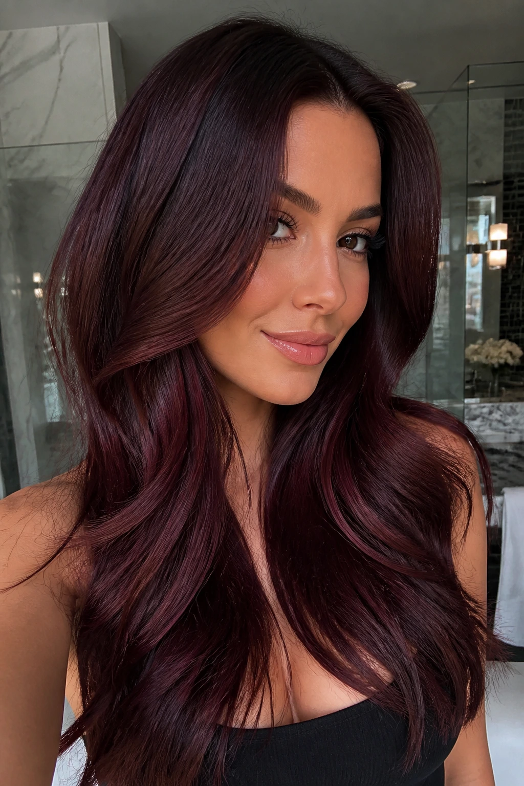 Portrait of a real woman with mahogany brunette hair showing red-violet depth and gloss.