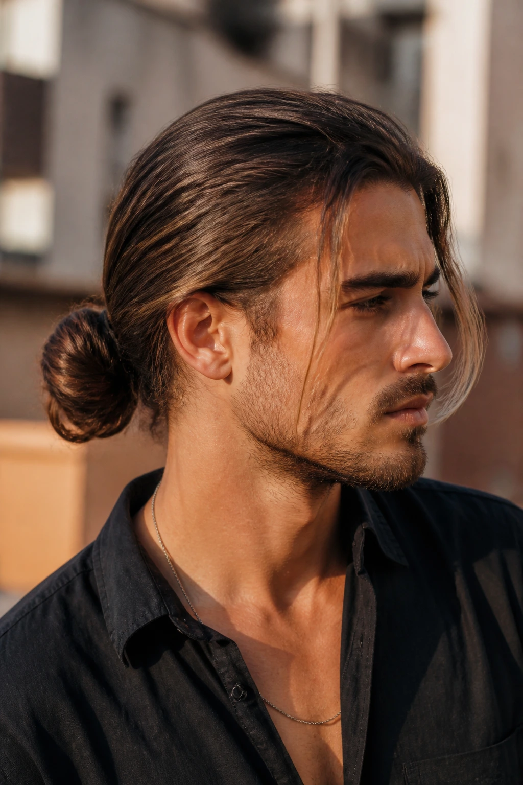 Portrait of a man with a low loose bun in an urban setting