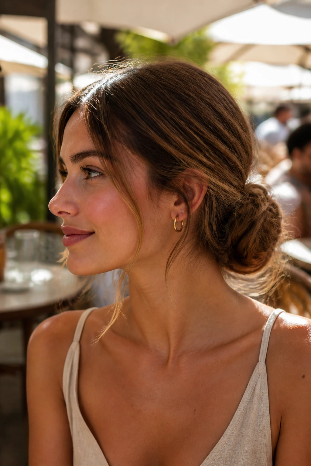 Close-up of shoulder-length hair styled in a low chignon in sunny outdoor setting.