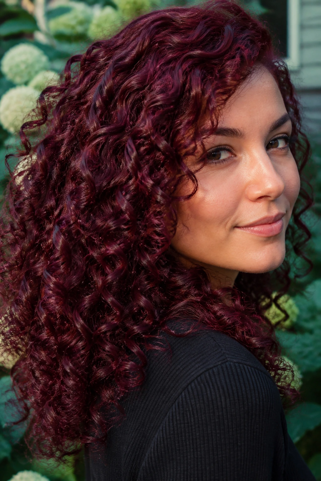 Close-up of a real woman with merlot curls in natural light