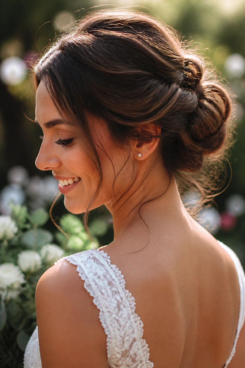 Close-up of a real bride with a messy bridal bun and soft tendrils framing the face