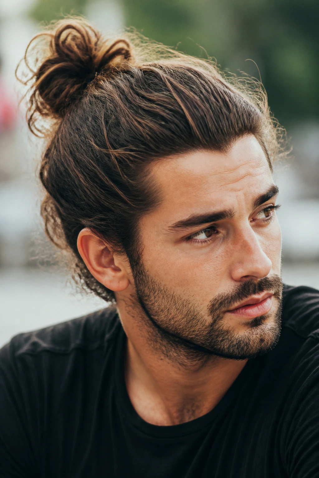 Portrait of a man with a messy top knot outdoors