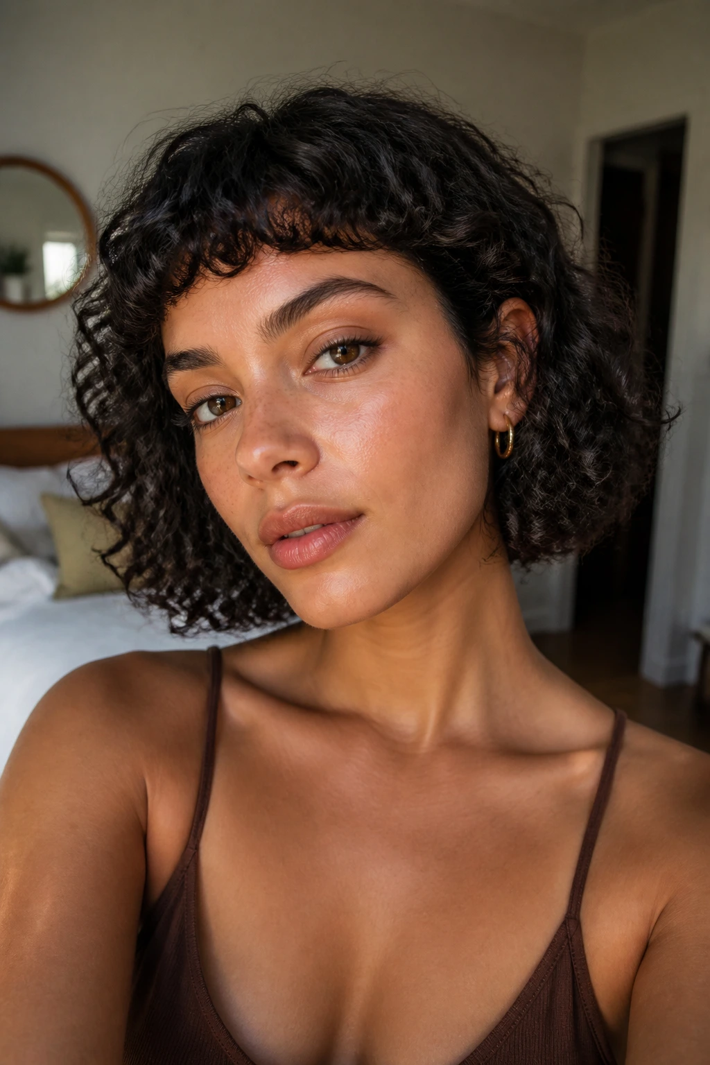 Close-up portrait of a real woman with micro bangs on curly hair