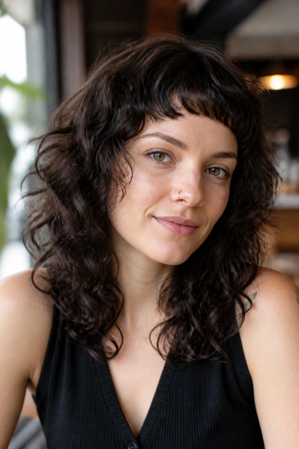 Portrait of a real person with a micro fringe on thick curly hair, front bangs short and dramatic.