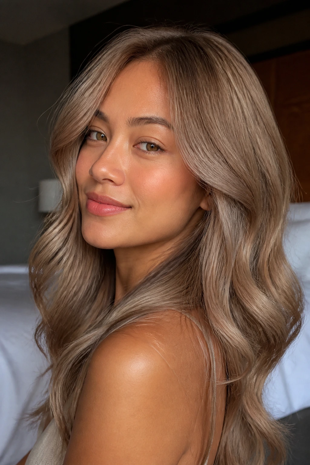 Close-up portrait of a real woman with milk tea blonde beige-gold hair in soft window light