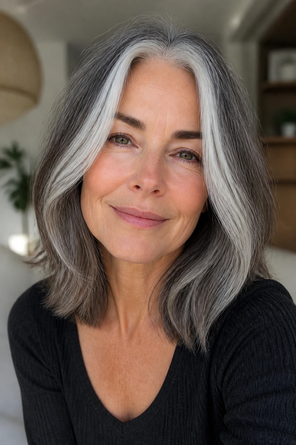 Close-up of a real woman with shoulder-length gray hair and moonstone money pieces framing the face