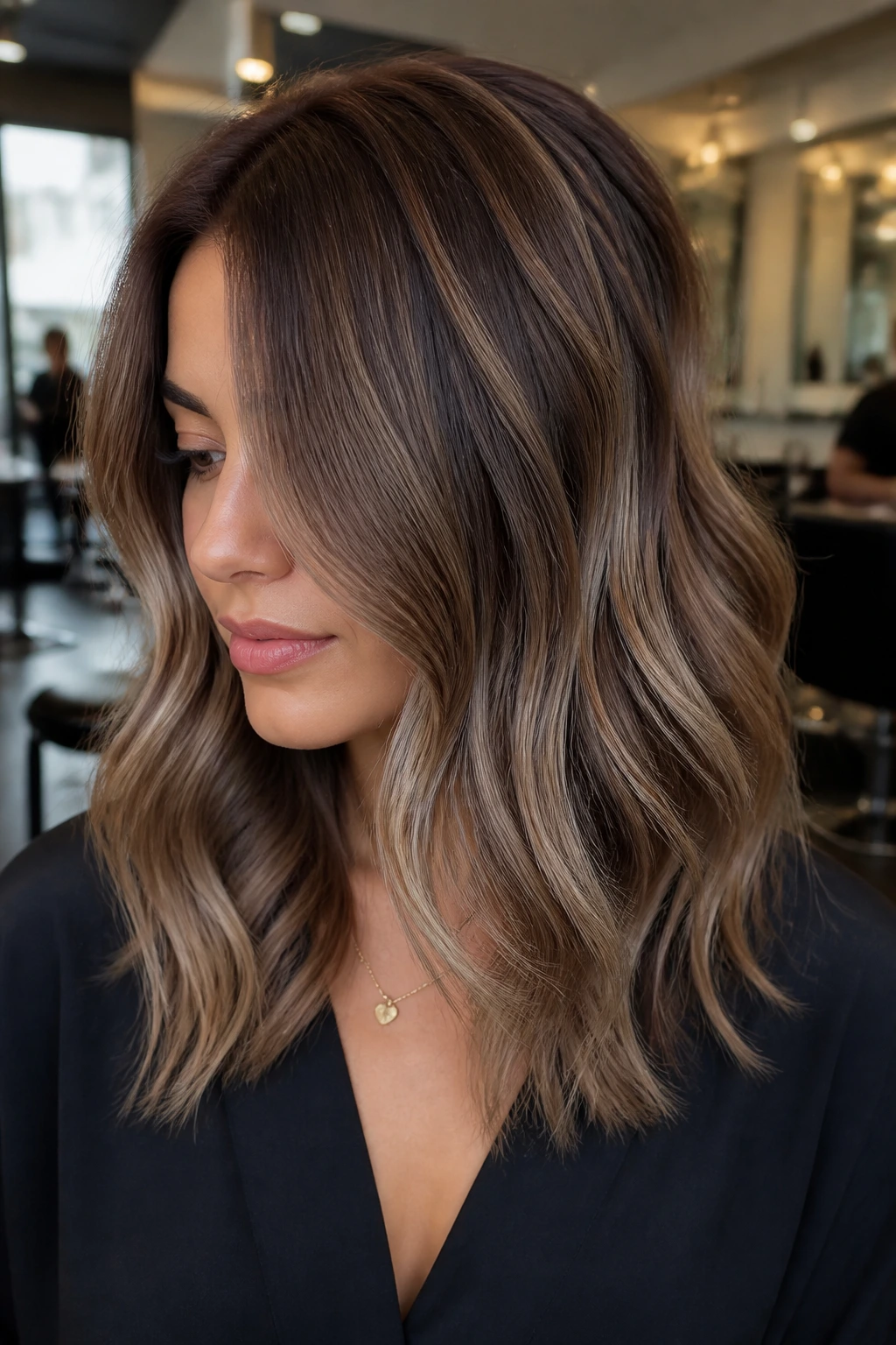 Brunette with mushroom brown balayage showing muted taupe and beige ribbons in mid-lengths.