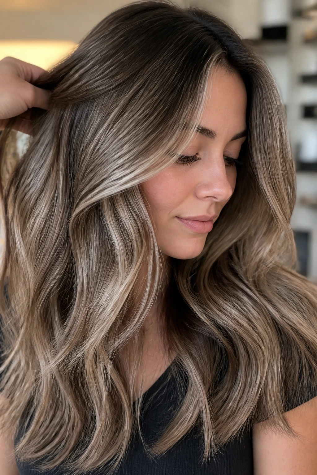 Close-up of thick hair with taupe-brown lowlights on a real person