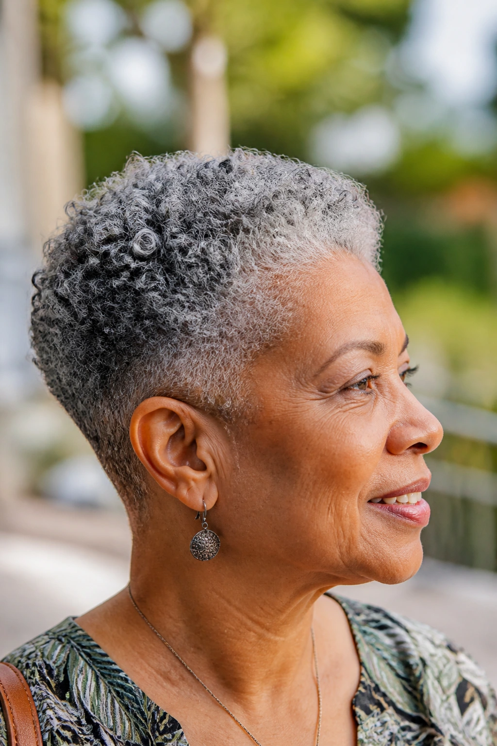 Close-up of a real person with natural gray coils and tapered sides in daylight