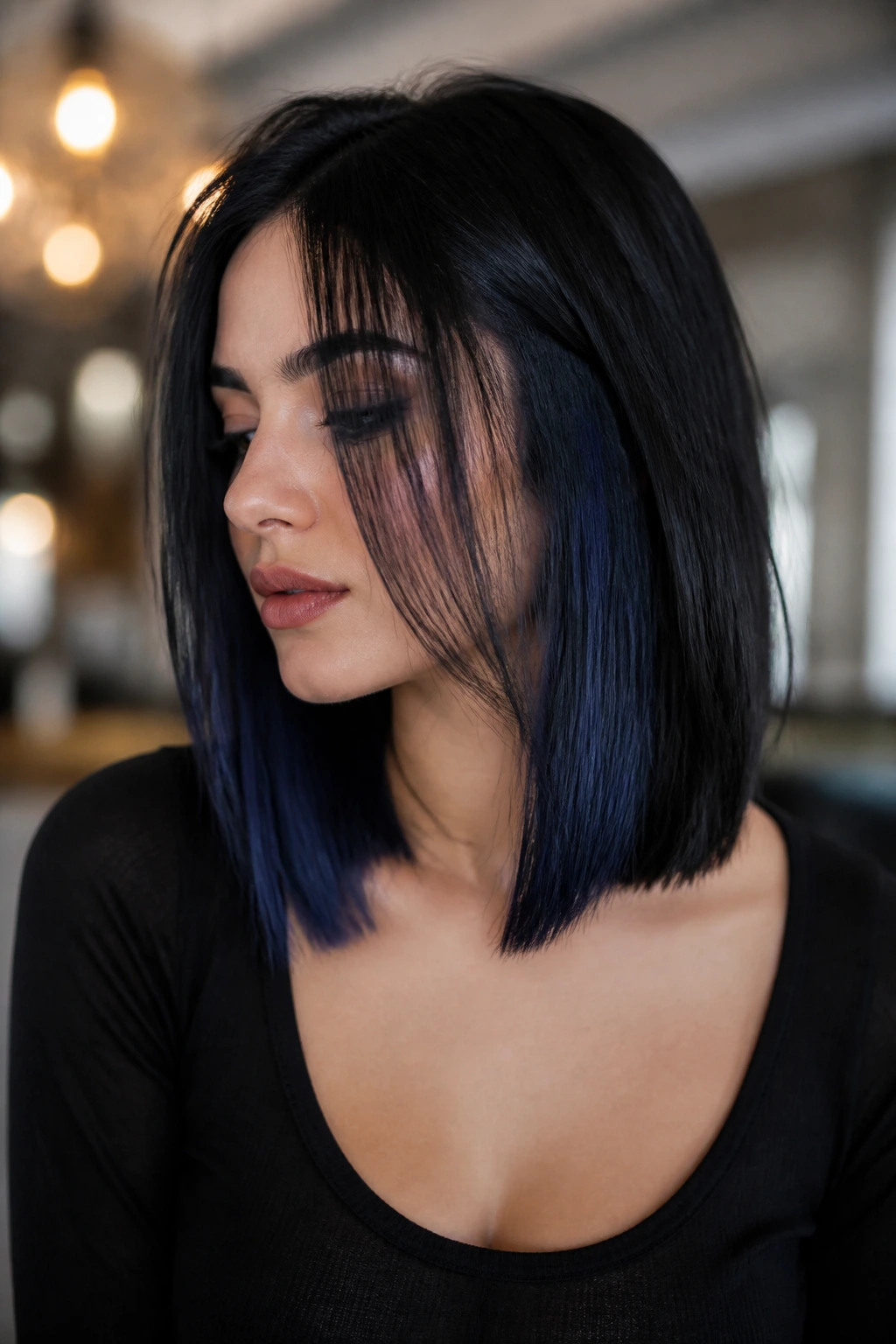 Portrait of a woman with shoulder-length hair showing a smoky navy peekaboo underlayer.
