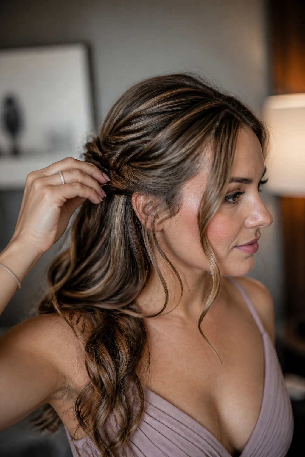 Bridesmaid adjusting half-up hairstyle in a dressing room
