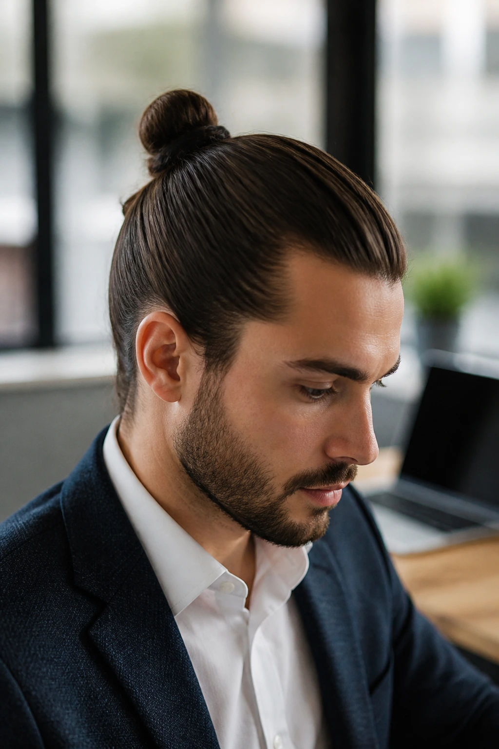 Close-up portrait of a man with an office-ready knot hairstyle in an office setting