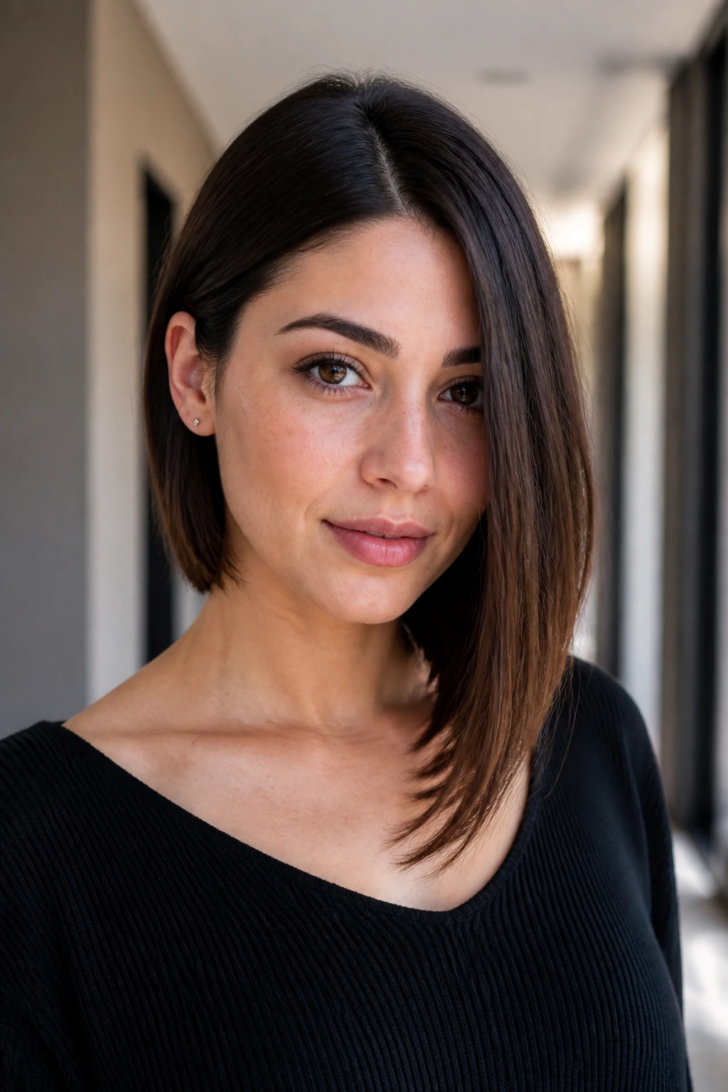 Real woman with one-side-tucked minimal bob in hallway.