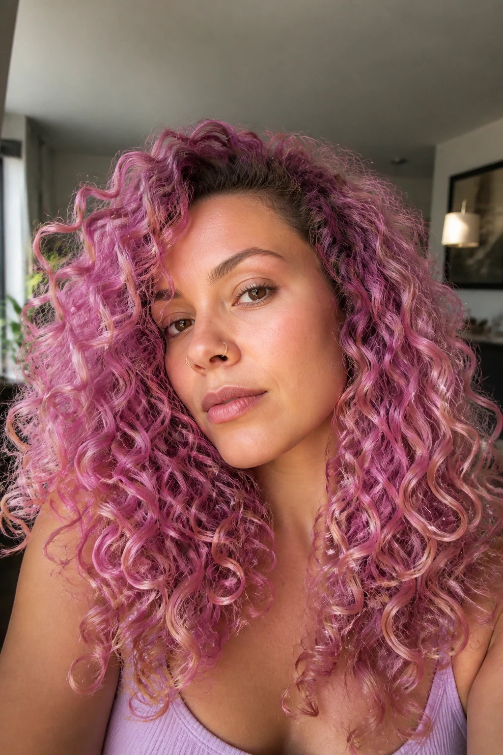 Real woman with orchid pink curls in bright living room