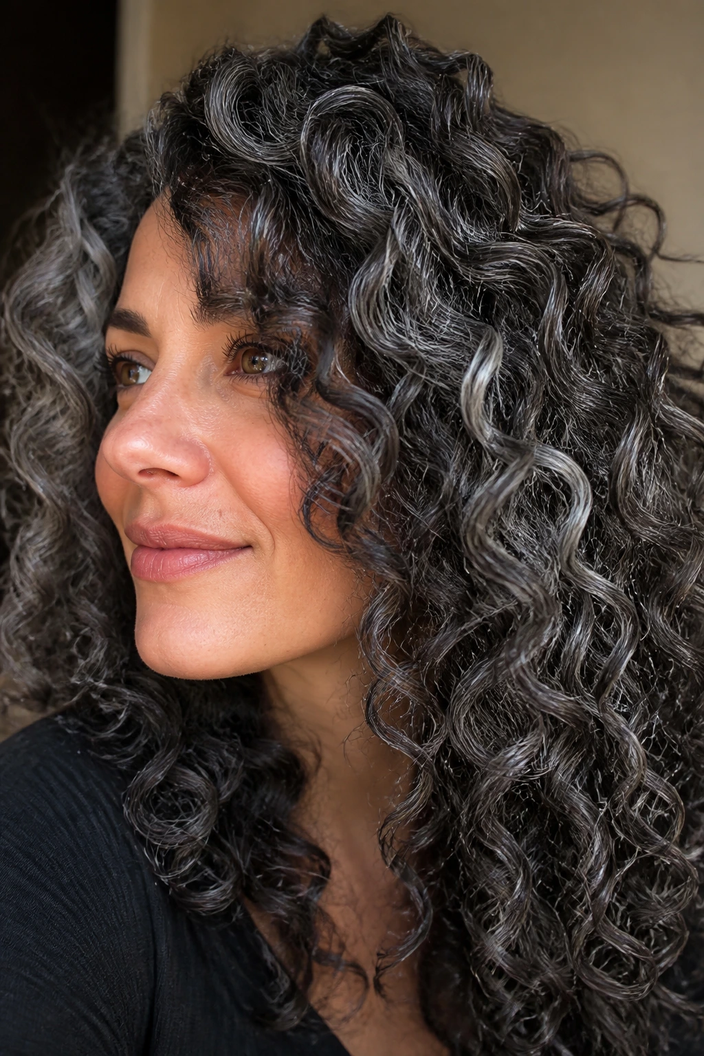 Close-up of a person with pewter babylights in curly hair