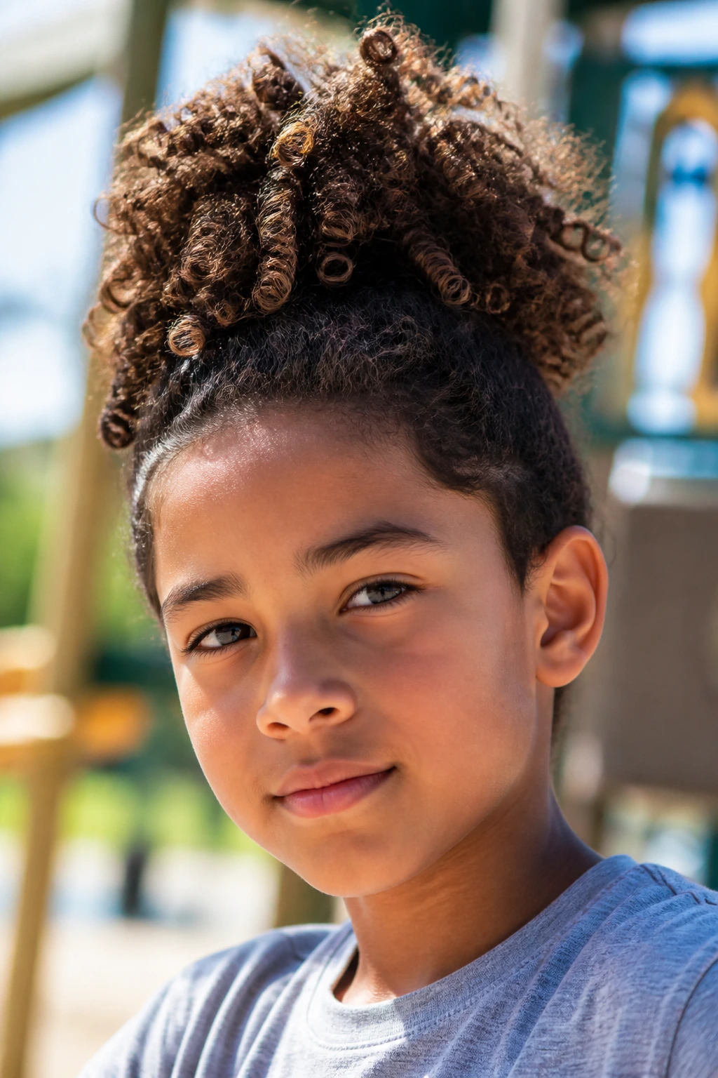 Close-up of a real boy with a high pineapple ponytail on a sunny day