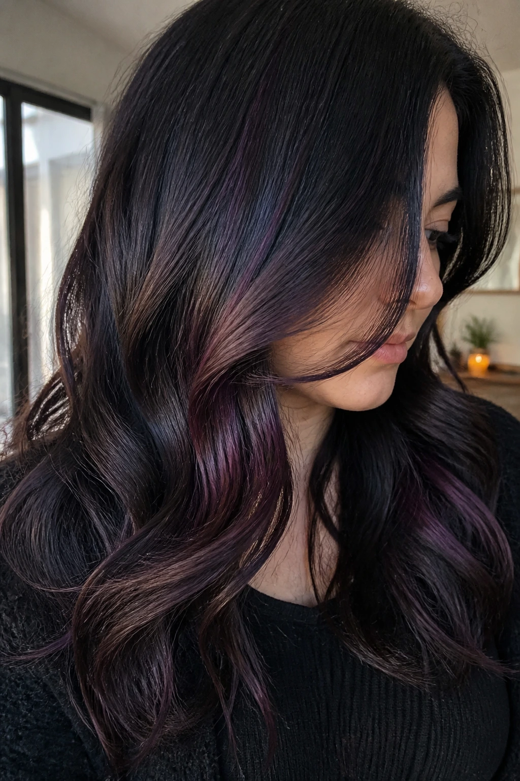 Close-up portrait of dark hair with plum lowlights peeking under the top layer