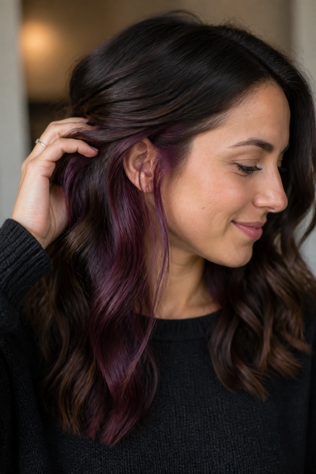 Close-up of brunette hair showing hidden plum panels peeking through at the ear