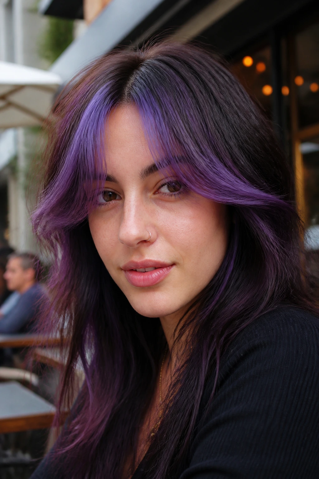 Close-up of a person with purple curtain bangs framing the face