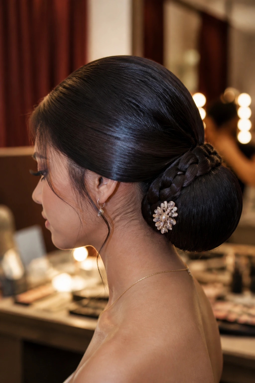 Close-up portrait of a real woman with a polished low bun quinceañera hairstyle in a backstage dressing area