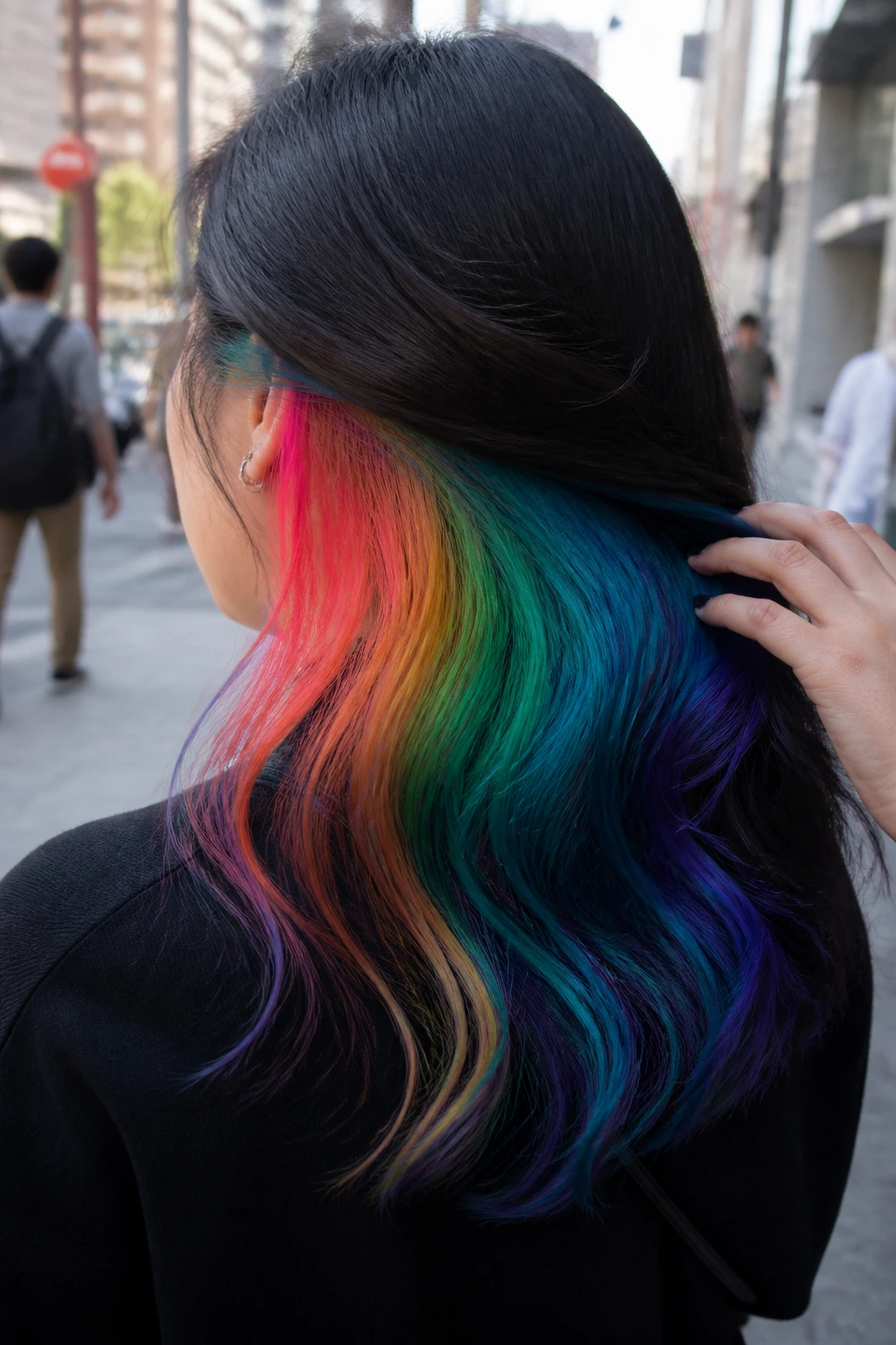 Back view of a real woman with dark hair and rainbow underlayer panels