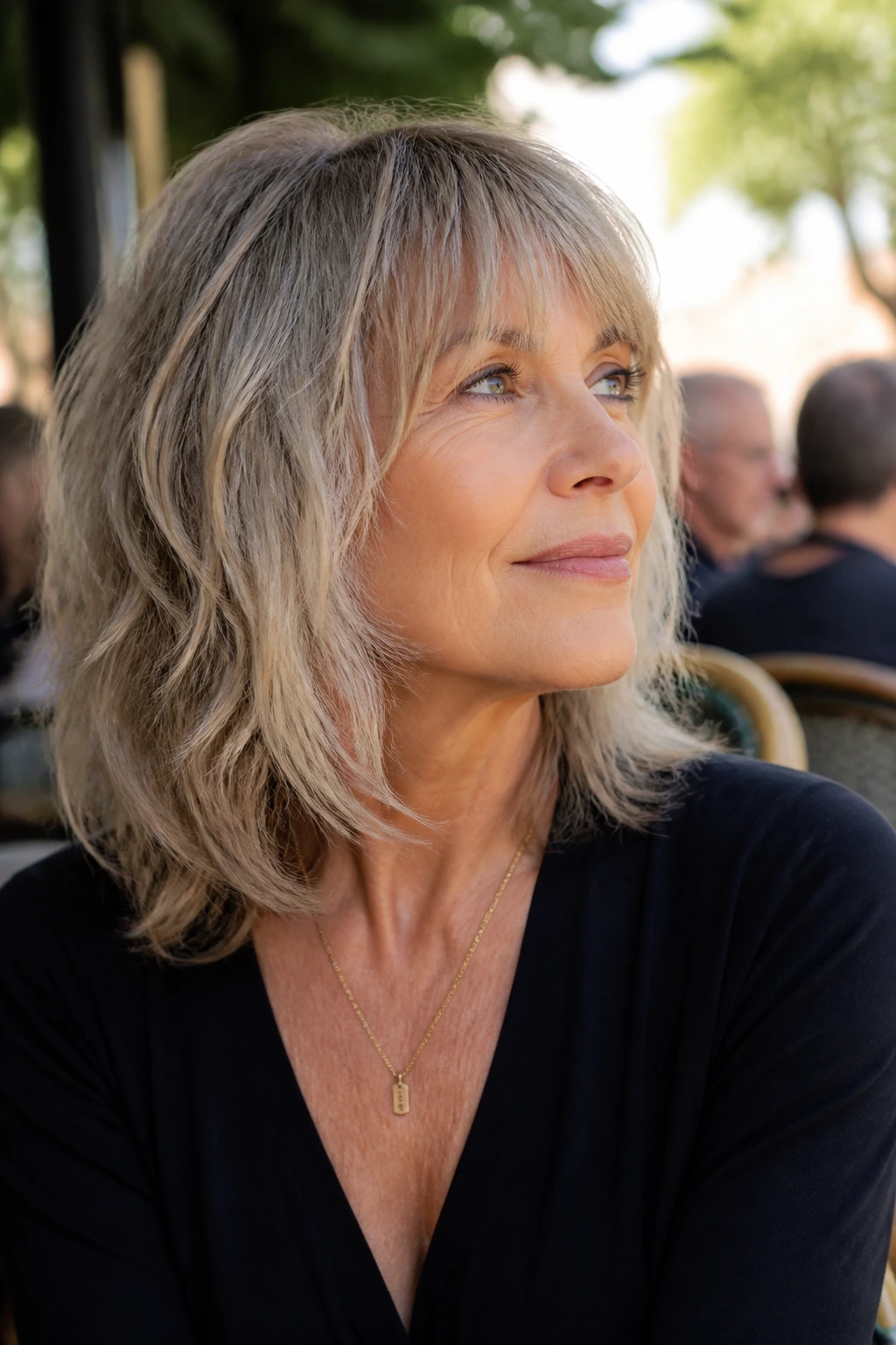 Real woman with shoulder-length razor-cut shag in outdoor cafe light
