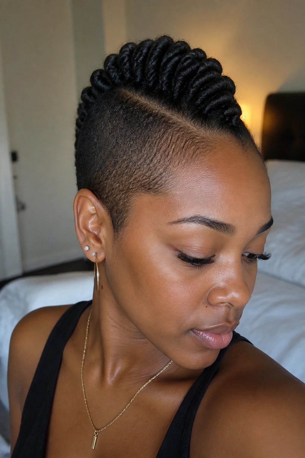 Close-up portrait of a real person with a rope-twist mohawk featuring a neat center line and tucked ends