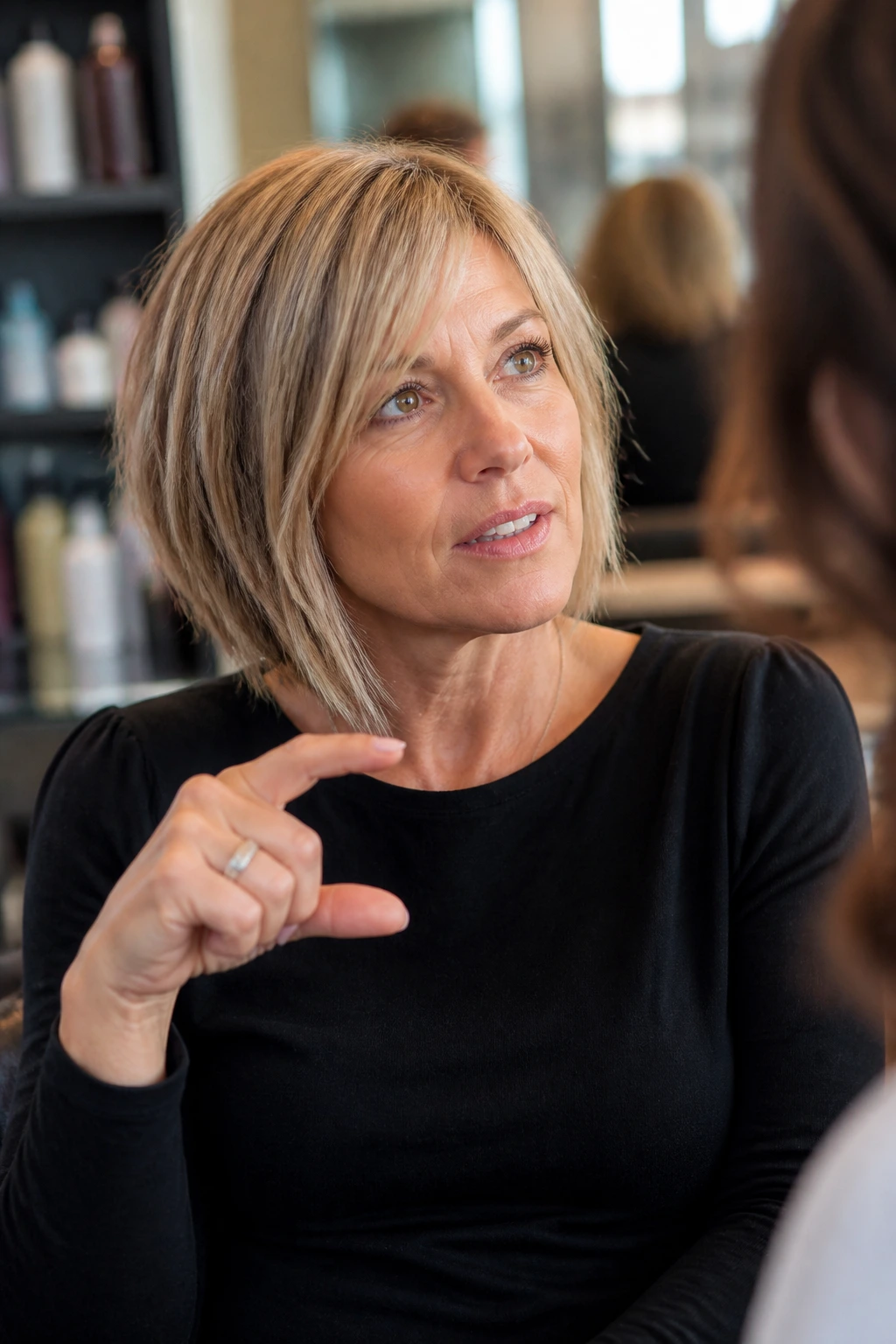 Real woman in salon chair discussing haircut with stylist