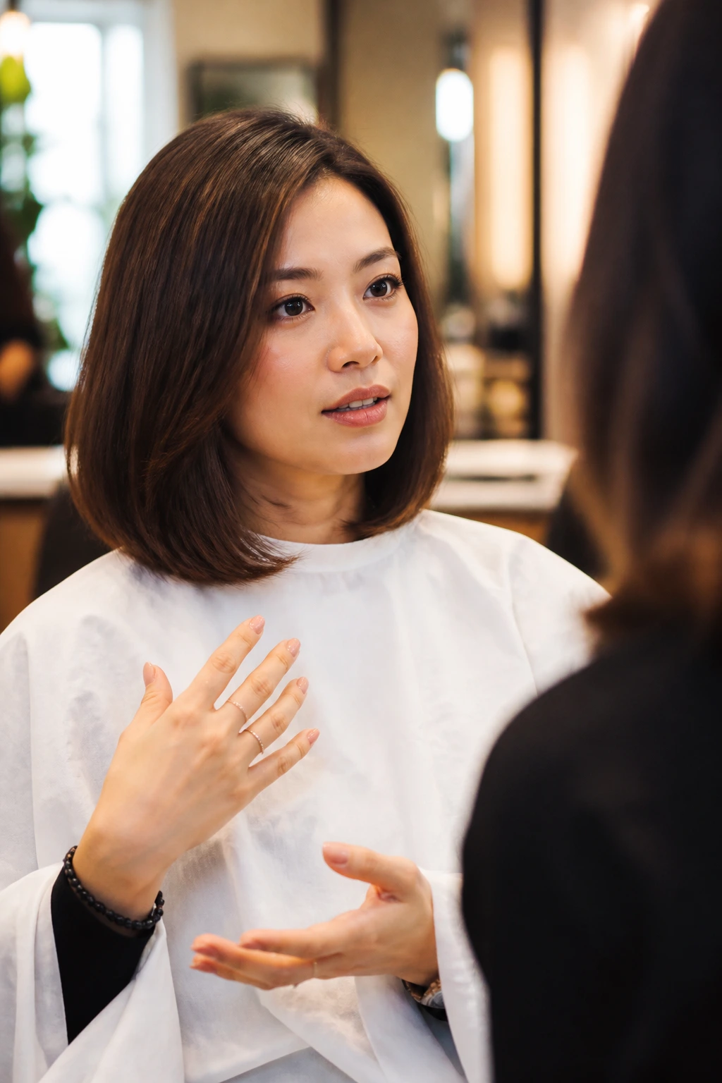 Close-up portrait of client discussing haircut with stylist off-frame in salon