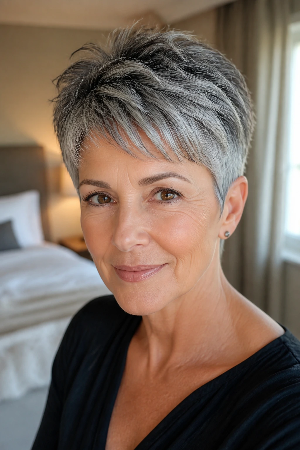 Close-up of a real woman with a salt-and-pepper pixie showing dimensional layers.