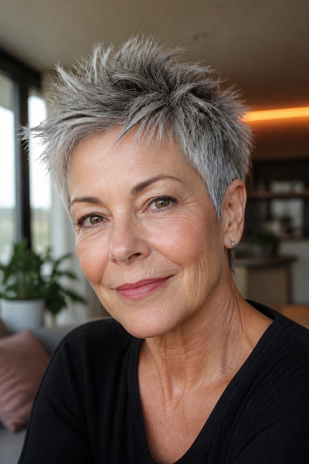 Close-up of a real woman with salt-and-pepper short top styled into soft spikes