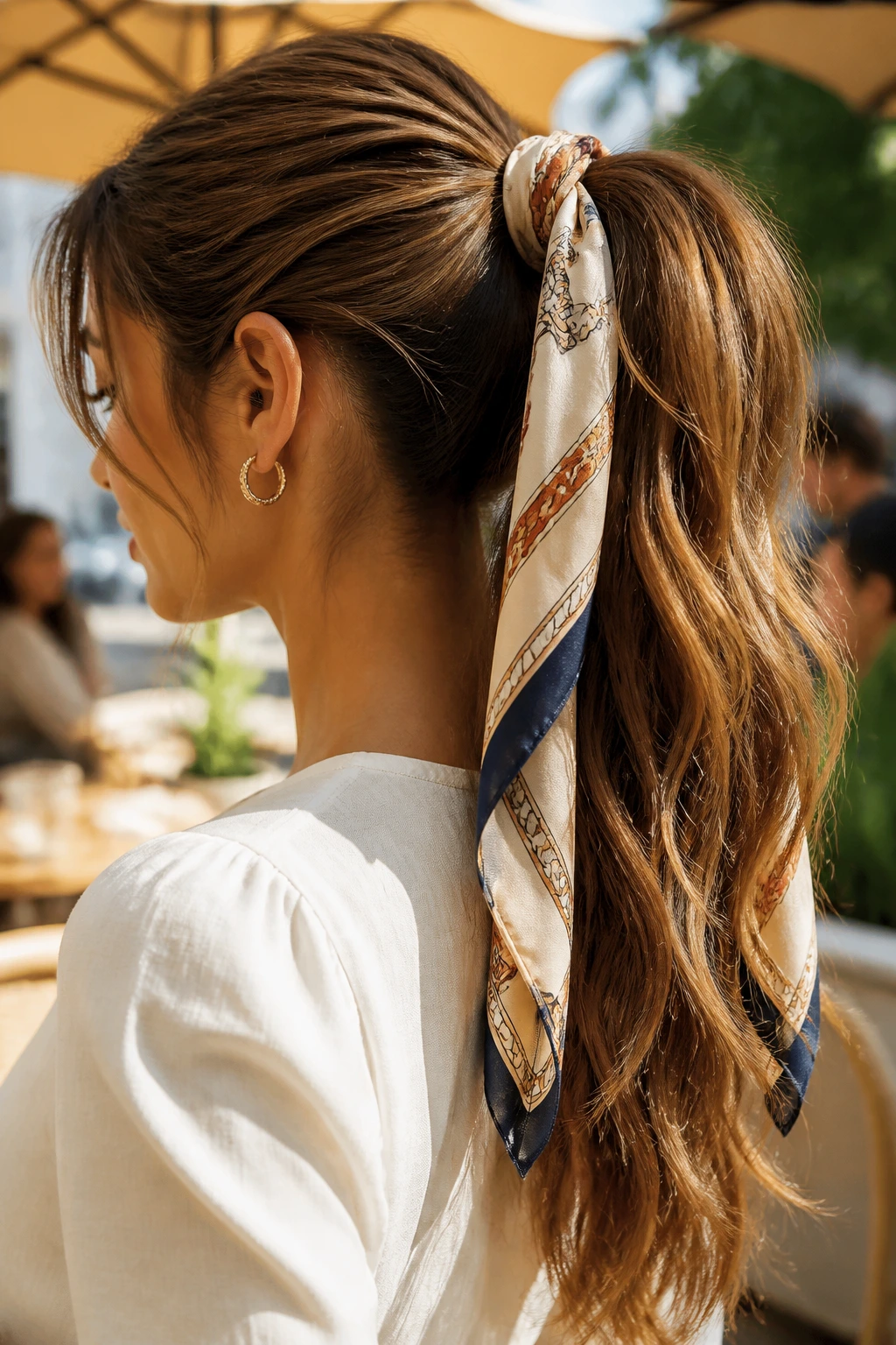 Portrait of a real woman wearing a scarf-tied ponytail in a sunlit outdoor setting