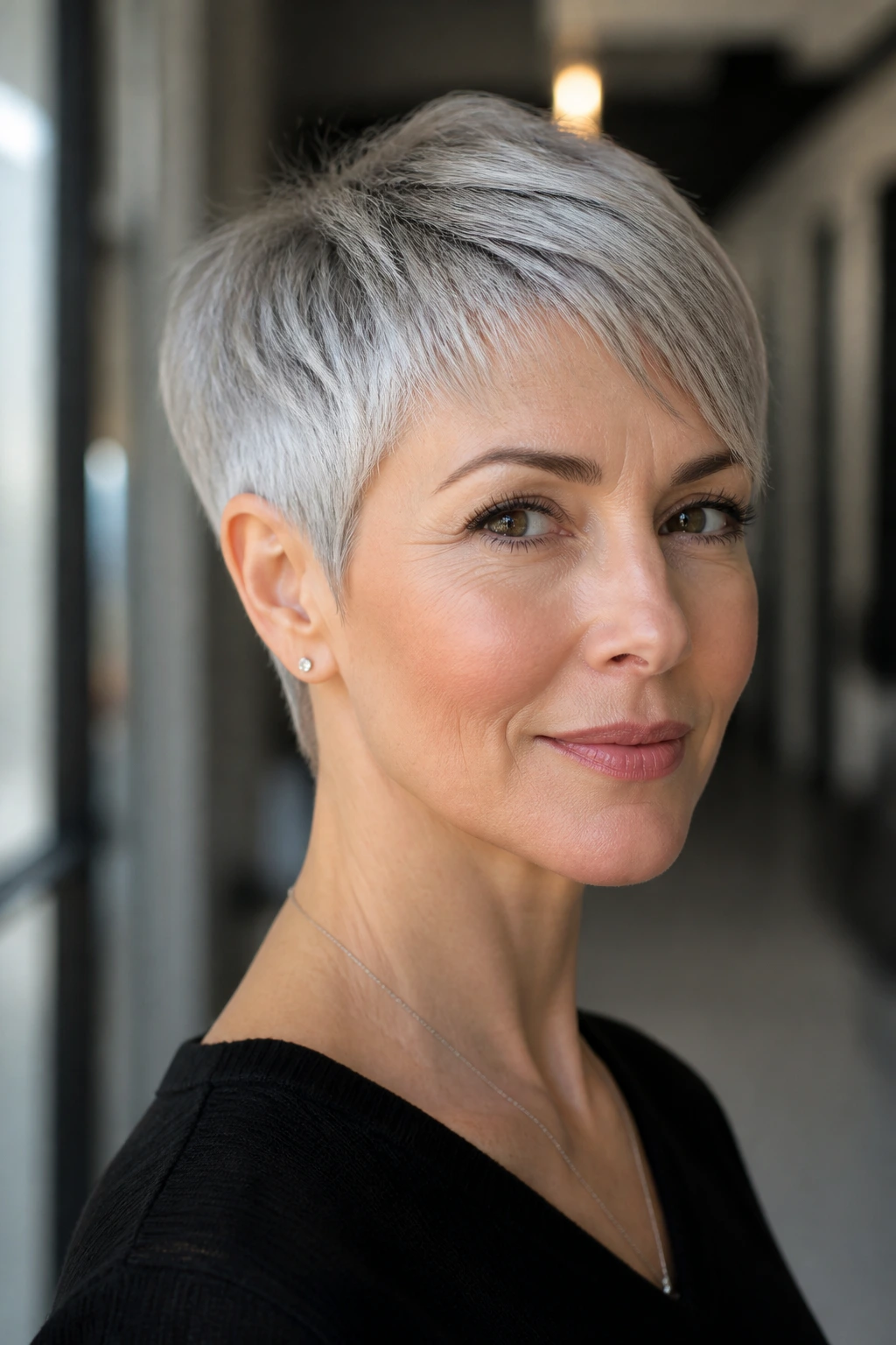 Real woman with sculpted pixie haircut balanced proportions in an urban hallway