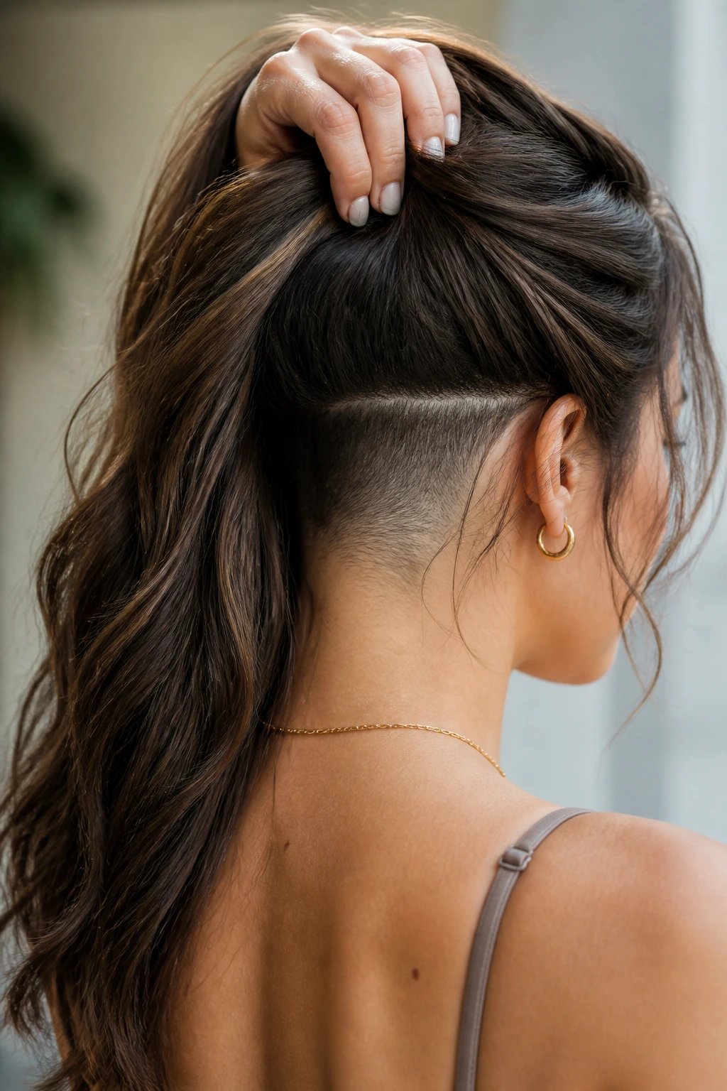 Portrait of a woman with long hair showing a secret undercut under the top layers