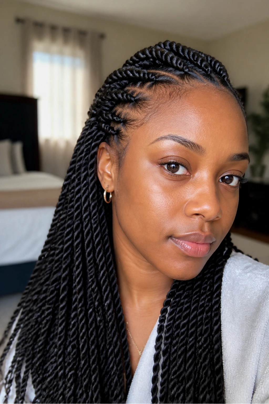 Close-up of a real woman with neat Senegalese twists, framed head-and-shoulders in warm natural light
