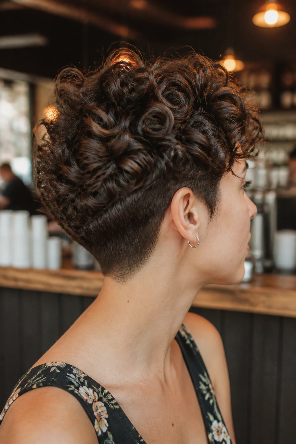 Real person with a short curly cut and tapered nape