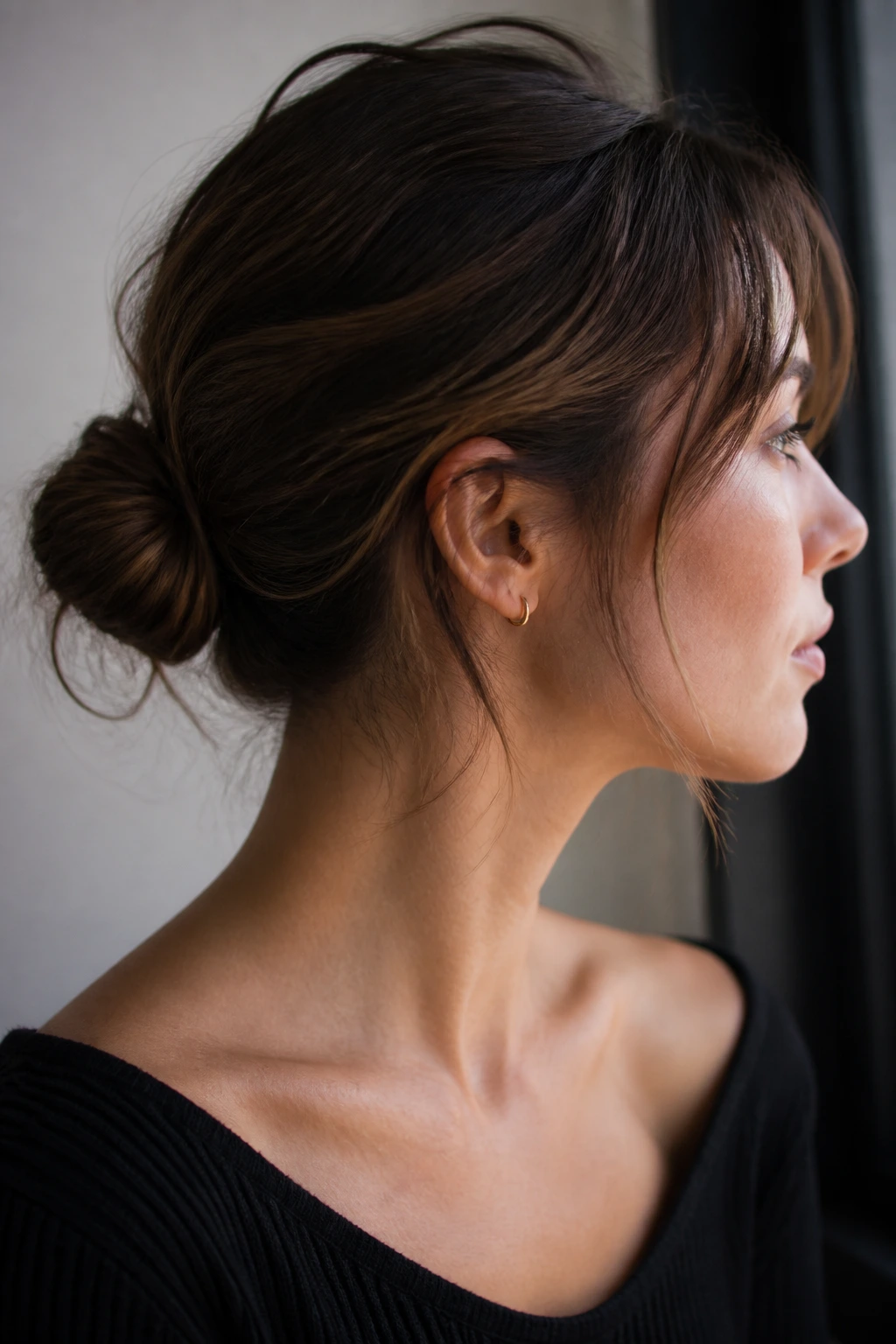 Close-up of real person with a small bun on short hair showing a soft hold.