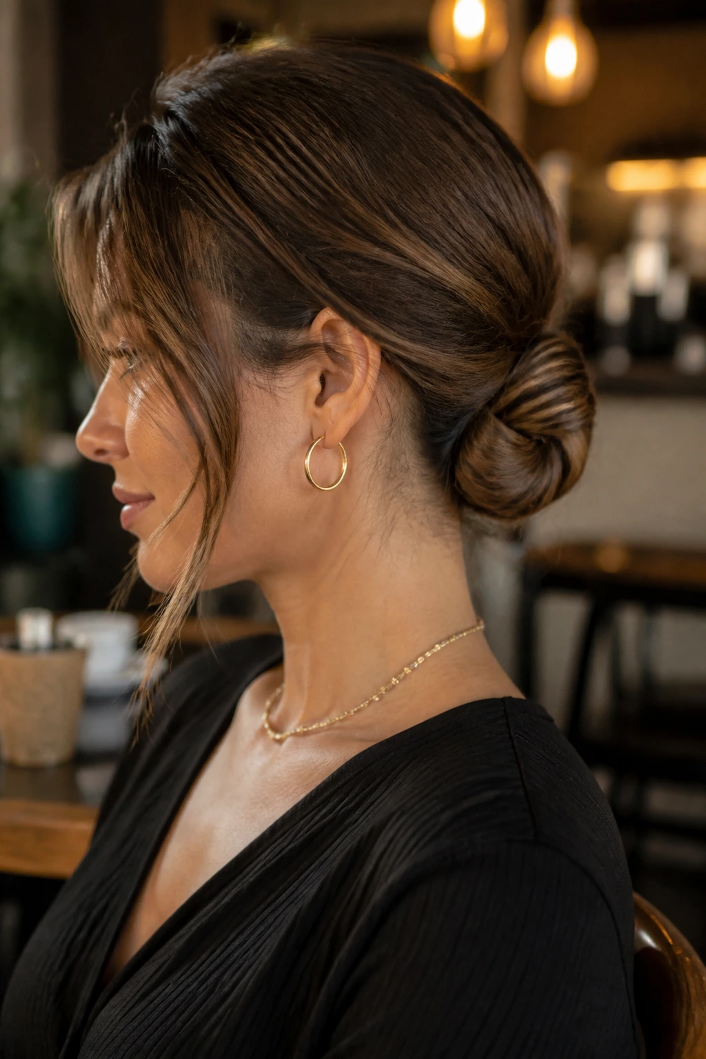 Profile view of a real woman with a short-to-medium chignon at the nape