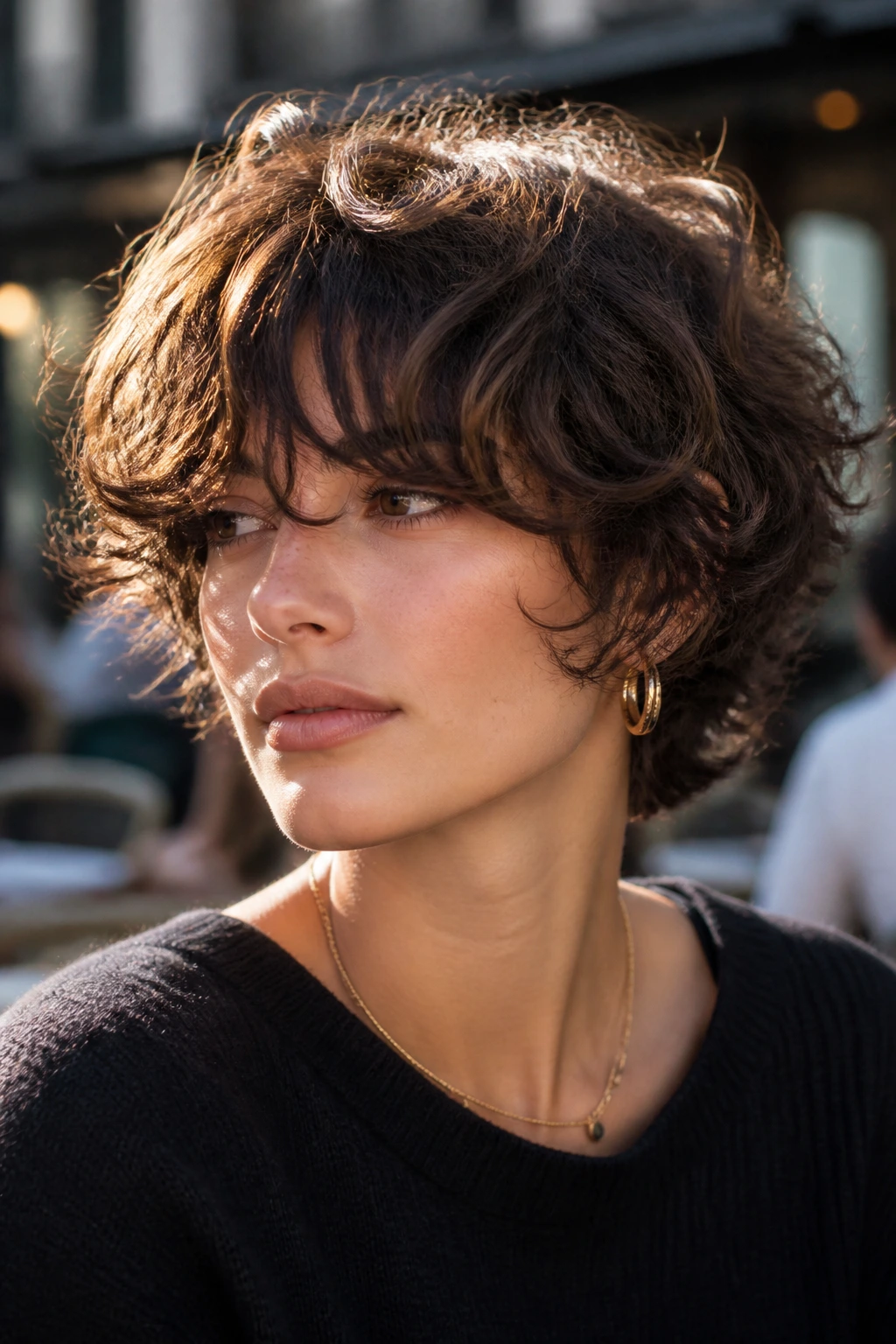 Close-up of a person with short volume curly shag and eye-skimming bangs.