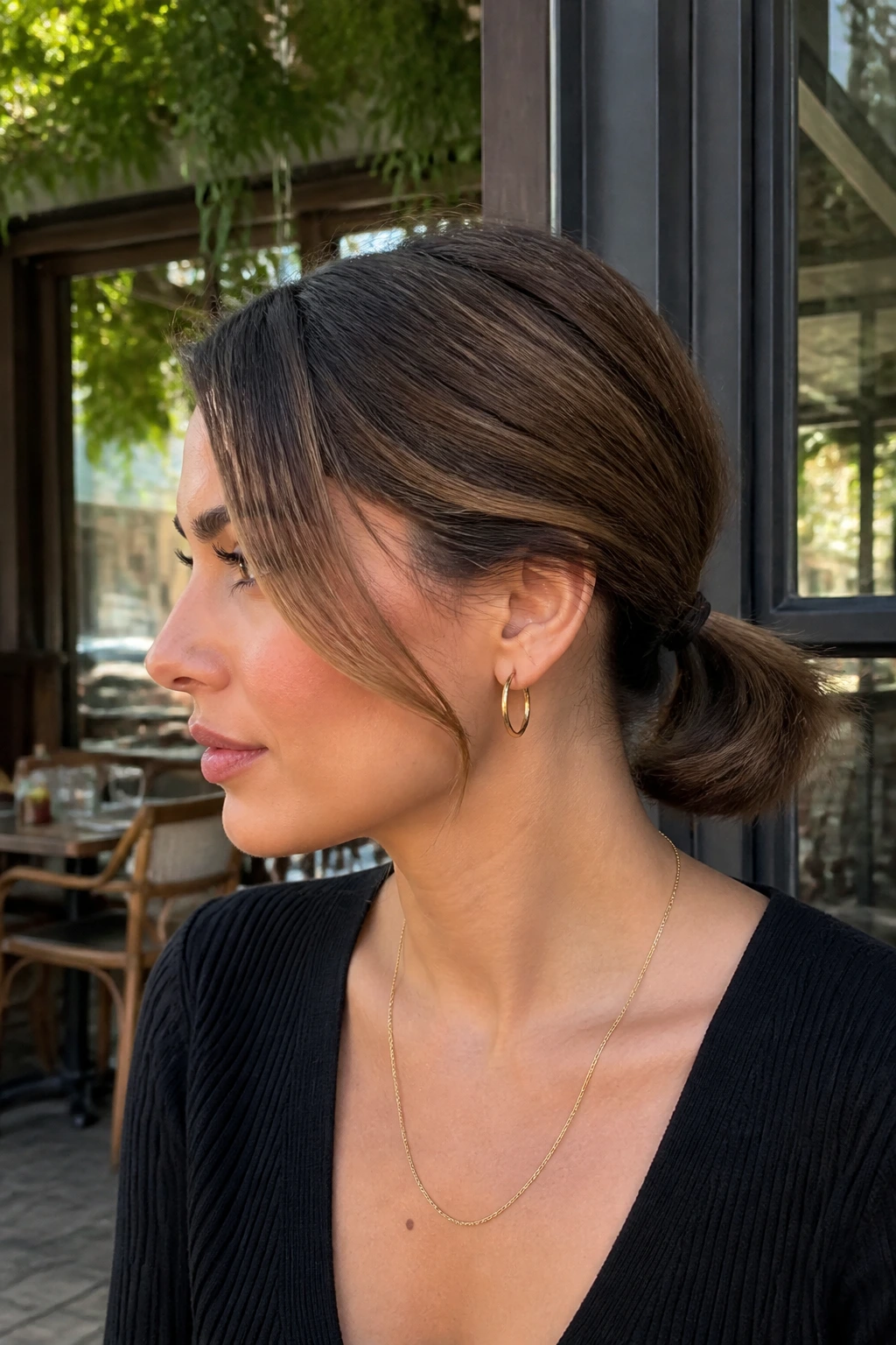 Profile view showing a deep side part and a low ponytail at the nape
