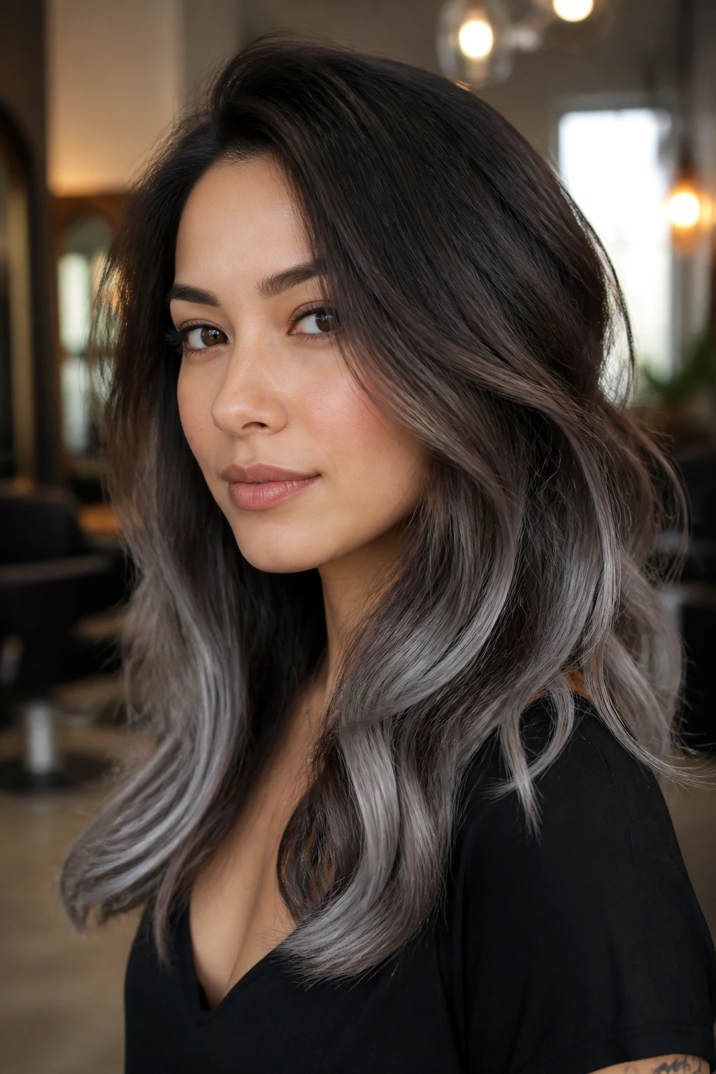 Close-up portrait of a person with dark brown to graphite silver hair in a salon.