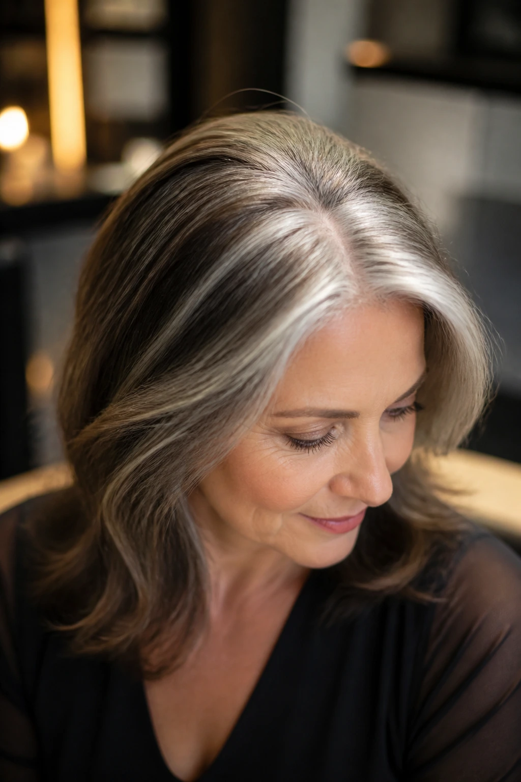 Close-up of a real woman's hair with a silver crescent highlight along the part
